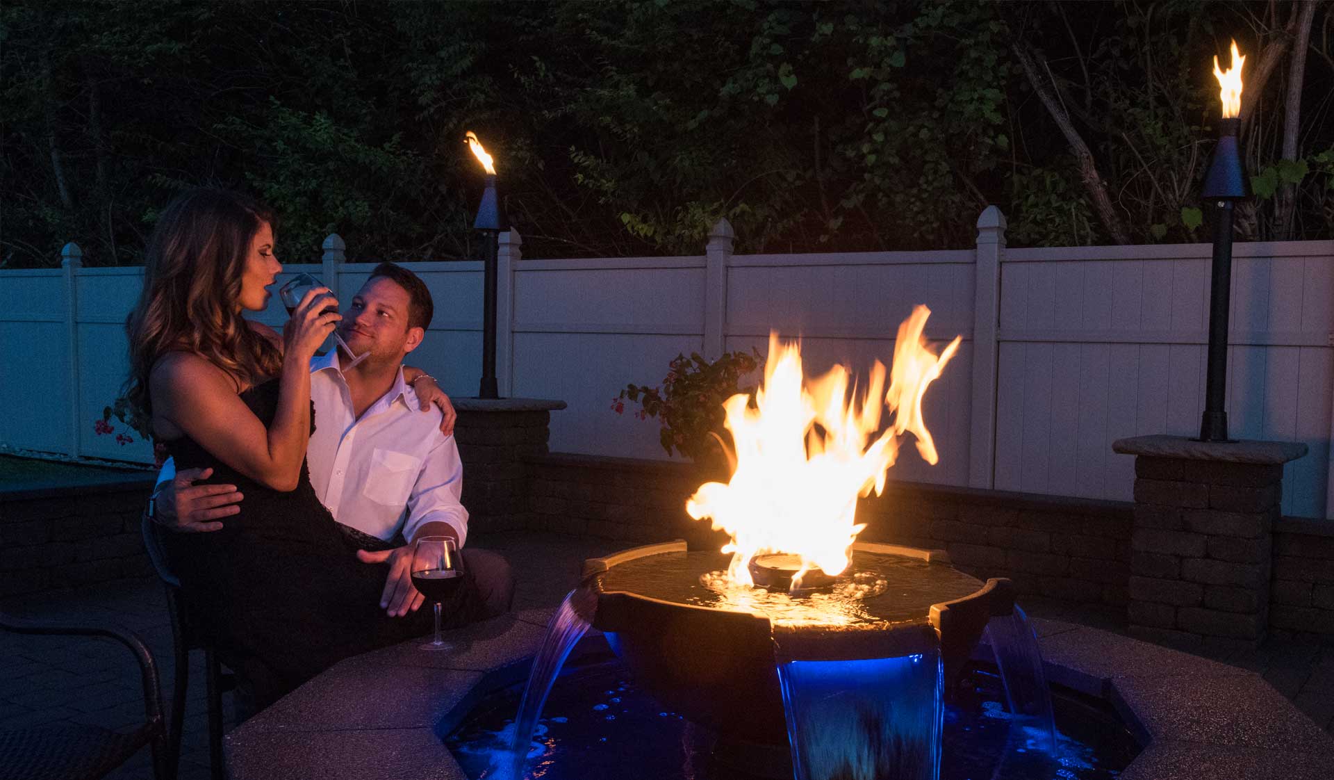 Couple enjoying the H2Onfire fire and water feature with Tiki Torches in the background